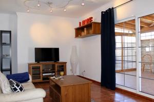 a living room with a couch and a tv at Casa Enamorado in Tarajalejo