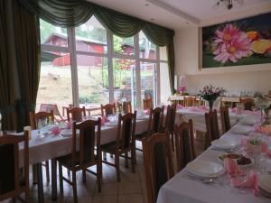 a dining room with white tables and chairs and a window at FALA na WYSPIE in Sobieszewo