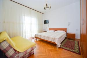 a bedroom with a bed and a couch in it at Apartman Nikodem in Novalja