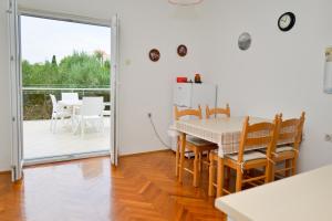 a kitchen and dining room with a table and chairs at Apartman Nikodem in Novalja +17 photos