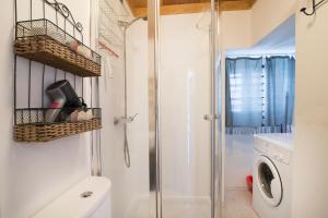 a bathroom with a shower and a washing machine at Alfama Apartment in Lisbon