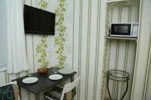 カリーニングラードにあるУютные апартаменты у Верхнего озераの壁にテーブルと電子レンジが備わる客室です。