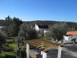 a wooden bench sitting on top of a parking lot at Casa de São José in Sardoal