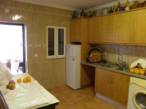 een keuken met een witte koelkast en een wastafel bij Casa de São José in Sardoal