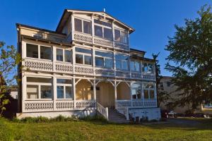 ein großes weißes Haus mit Balkon in der Unterkunft Am Ostseegarten in Lohme