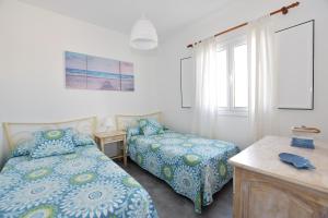 Un dormitorio con dos camas y un escritorio y ventana. en Casa El Lago, en Arrieta