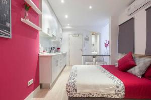 マドリードにあるEstudio en Calle Gravina - Chuecaのピンクの壁のベッドルーム1室(大型ベッド1台付)