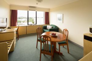 um quarto com uma mesa e cadeiras e uma sala de estar em Frontier Hotel Darwin em Darwin