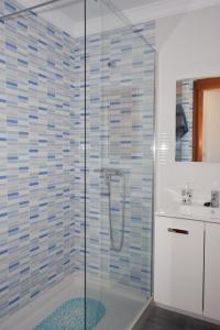 Un baño con ducha de cristal con lavabo. en Casa El Lago, en Arrieta 30 fotos más