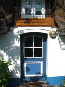 a blue door of a house with a window at Föhrer Friesenkate Ost in Nieblum