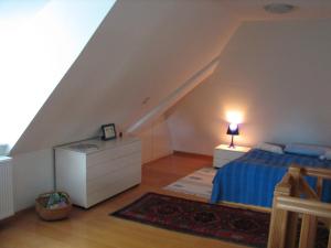 a bedroom with a blue bed and a white dresser at Föhrer Friesenkate Ost in Nieblum