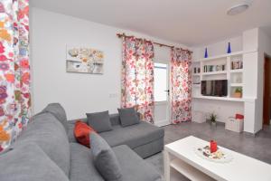 a living room with a gray couch and a table at Casa El Lago in Arrieta