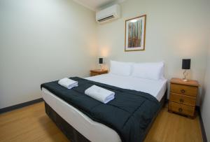 a hotel room with a bed and a lamp at Hidden Valley Holiday Park Darwin in Darwin