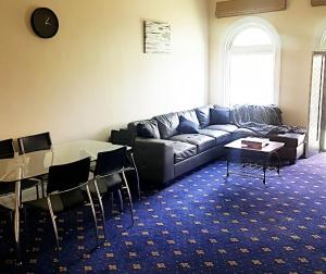 a living room with a couch and a table and chairs at The Wharf Hotel in Wynyard