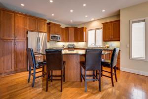 a kitchen with wooden cabinets and a island with bar stools at Adela's Bed and Breakfast in West Kelowna +33 photos