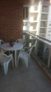 une table et des chaises blanches sur un balcon avec un bâtiment dans l'établissement Juventus, à Córdoba