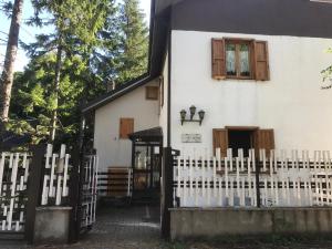 una casa blanca con una valla y una ventana en Villa delle tre lanterne, en Roccaraso