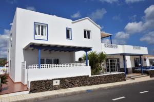 una casa blanca al costado de una calle en Casa El Lago, en Arrieta