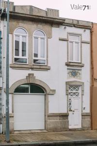 een wit huis met een witte garagedeur bij Vale71house in Porto