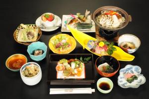 仙北的住宿－溫泉浴泊泊傳統日式旅館，餐桌,盘子上放着食物和碗