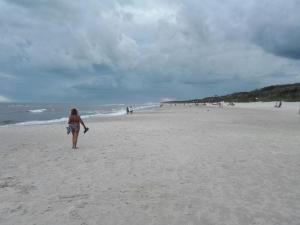 Una mujer caminando en una playa cerca del océano en Los Caranchos I, en Cuchilla Alta