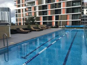 a large swimming pool in front of a building at Panoramic views in luxurious brand new apartment in Sydney