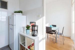 cocina con mesa y nevera blanca en Apartment Cozy 4YOU, en Oporto