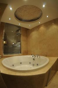 a bathroom with a large tub with a large mirror at Shmayaa Hotel in Midyat