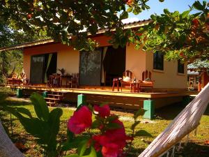 ein Haus mit einer Veranda mit Stühlen und einer Blume in der Unterkunft Fidelito Ranch & Lodge in Tambor