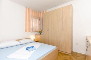 1 dormitorio con cama blanca y armarios de madera en Apartment Branka, en Srima