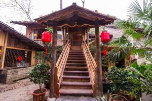 uma escada que conduz a um edifício com lanternas vermelhas em Rural House em Yangshuo