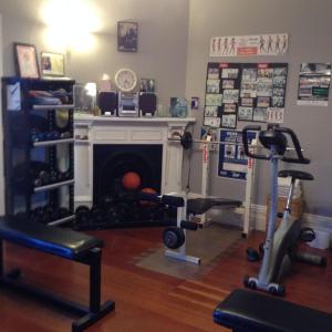 a room with a fireplace with exercise equipment in it at Ponsonby Boutique Villa with Private Gym in Auckland