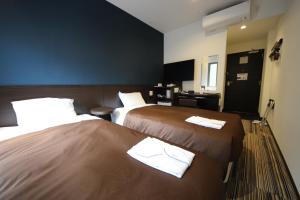 a hotel room with two beds with towels on them at Urbain Tokyo Ueno Kitasenju in Tokyo