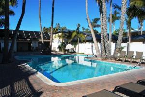 una piscina con palmeras en un resort en Capri Beach Accommodations at Capri By The Sea, en San Diego