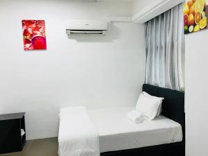 a small room with a bed and a painting on the wall at H-Hotel in Johor Bahru +2 photos