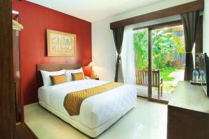 a bedroom with a bed with a red wall at Hotel Puriartha Ubud - CHSE Certified in Ubud