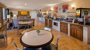 a restaurant with tables and chairs and a counter at Best Western Plus Pleasanton Inn in Pleasanton