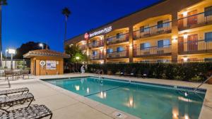 uma piscina em frente a um hotel à noite em Best Western Plus Pleasanton Inn em Pleasanton