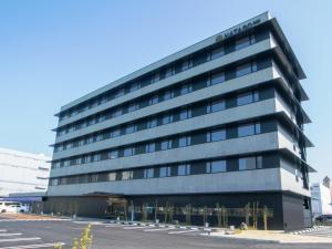 a large office building with a sign on it at HATAGO INN Kansai Airport in Izumi-Sano