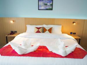 een groot wit bed met twee witte handdoeken erop bij Samui City Hotel in Chaweng Beach