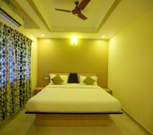 um quarto com uma cama e uma ventoinha de tecto em Kans One em Chennai