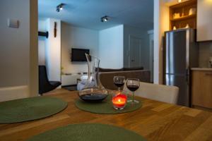 una mesa con dos copas de vino y una vela en "Rodzinny Apartament pod Śnieżką" na osiedlu "Apartamenty pod Śnieżką", en Karpacz