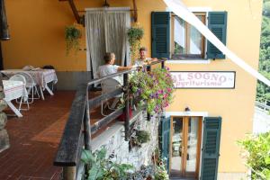 2 persone sedute su un balcone di un edificio di Agriturismo Il Sogno a Lorsica