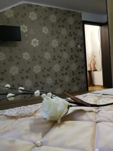 a vase of flowers sitting on top of a bed at House Apartment Minerilor in Cluj-Napoca