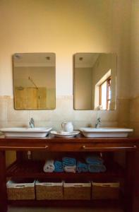 a bathroom with two sinks and two mirrors at Treehouse at Theebos in Strand