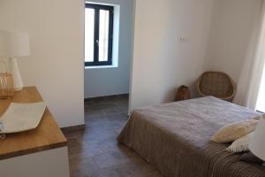 a bedroom with a bed and a table and a window at Maison Terre Ardente in Caves