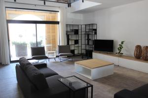 a living room with a couch and a tv at Maison Terre Ardente in Caves +17 photos