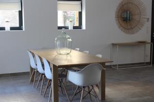a dining room table with a glass vase on it at Maison Terre Ardente in Caves