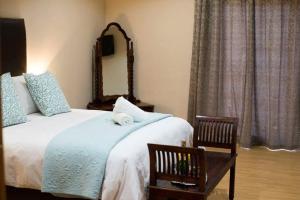 A bed or beds in a room at The Graaff-Reinet Suites