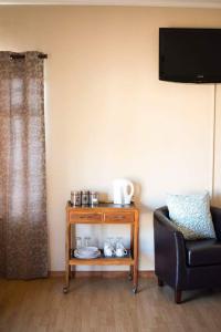 een woonkamer met een tafel en een stoel bij The Graaff-Reinet Suites in Graaff-Reinet